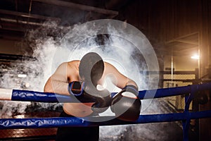 Exhausted man with bowed head down in ring