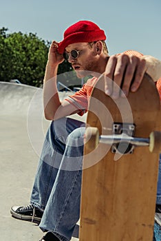 exhausted man sitting with blurred skateboard