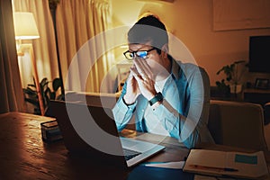 Exhausted man working late on laptop in night from home