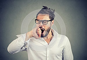 Exhausted man yawning with eyes closed