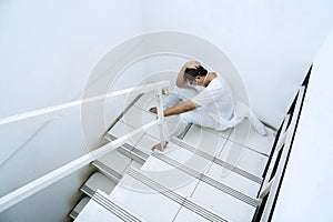 Exhausted medical worker sitting on stairs