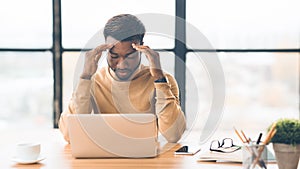 Exhausted millennial black businessman having migraine attack