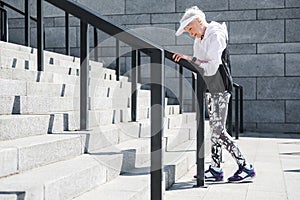 Exhausted old woman having time to rest before raising upstairs