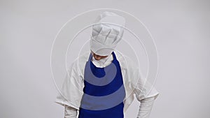 Exhausted overburdened little cook making kill me gesture posing at white background. Portrait of tired Caucasian boy in