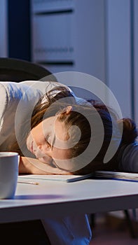 Exhausted overload business woman falling asleep on desk