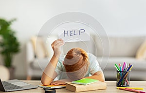 Exhausted schooler doing homework, showing help card