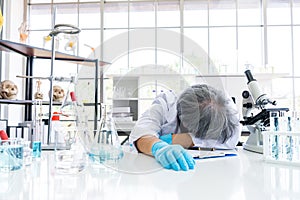 Exhausted scientist sleeping in laboratory. People lifestyles and occupation concept. Science and experiment in lab theme photo