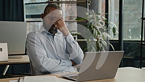 Exhausted sick mature senior businessman tired African American ethnic man office executive work on computer typing feel