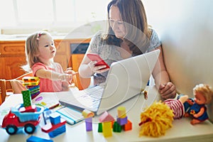 Exhausted and stressed mother working from home with toddler