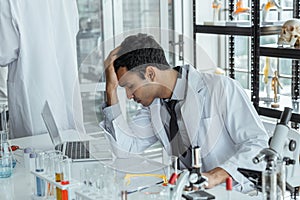 Exhausted stressed research scientists feeling tired worried about problem in chemical laboratory