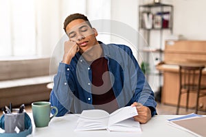Exhausted student guy asleep on study books