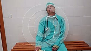 Exhausted surgeon sitting on a bench