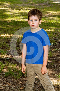 Exhausted and Sweaty Little Boy Stands Slumped With Arms Hanging photo