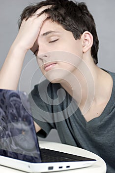 Exhausted Teen Works On Computer