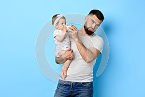 Exhausted , tired father feeding his baby girl with milk bottle