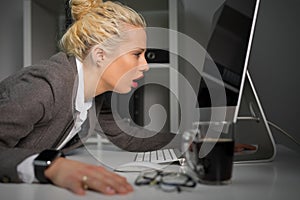 Exhausted and tired woman looking at computer screen very close