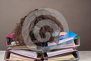 Exhausted tired woman sleeping on a pile of file folders, burnout, stress and overworked, pressure at work