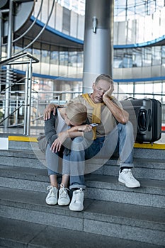 Exhausted tourist couple napping at the airport terminal