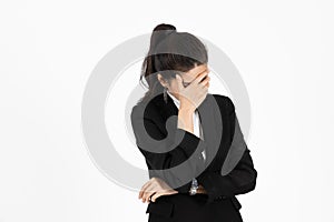 Exhausted upset Asian business woman with hands on face suffering from severe depression on white  background.