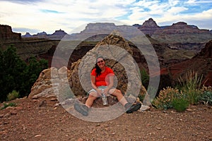 Exhausted woman backpacker resting on the New Hance Trail in the Grand Canyon.