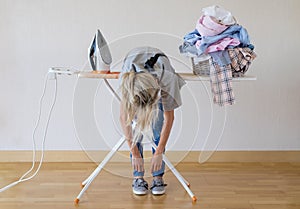 Exhausted woman lying on ironing desk