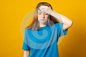 Exhausted woman makes face palm, looks bothered and unitnerested, feels unhappy and tired, dressed casually