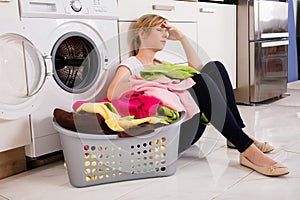 Exhausted Woman Sitting Near Washing Machine