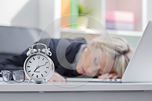 Exhausted woman sleeping in front of computer