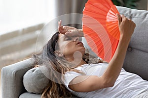 Exhausted woman use hand fan suffer from heat photo