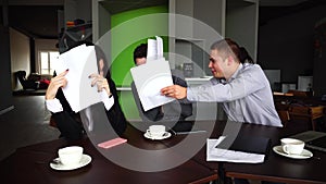 Exhausted workers of company, female and male fools and do not want to work with documents in hand are sitting at table