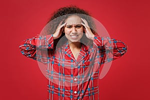 Exhausted young african american girl in pajamas homewear posing resting at home isolated on red background. Relax good