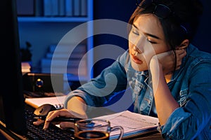 Exhausted young Asian creative feeling sleepy, looking on pc. Stratagem.