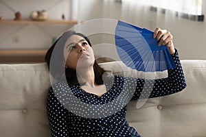 Exhausted young asian woman fanning herself suffering from extreme heat