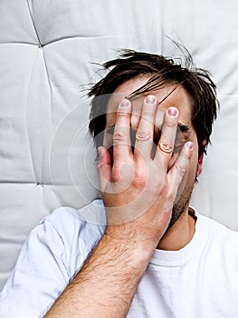 Exhausted Young Man on Bed - Frustrated Man photo
