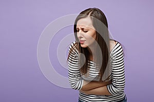 Exhausted young woman in striped clothes posing isolated on violet purple background. People lifestyle concept. Mock up