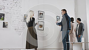 Exhibition in an art gallery. Art connoisseurs inspect the abstract works of a contemporary artist. Men and women spend