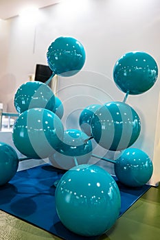 An exhibition of blue balls arranged in the shape of a crystal. The arrangement of the beads resembles a DNA double helix, with