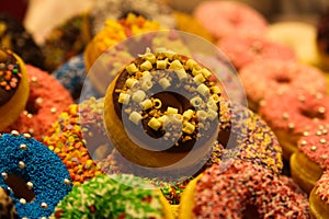 Exhibition of colorful donuts decorated with fancy crumbles in the market hall of Rotterdam, Netherlands