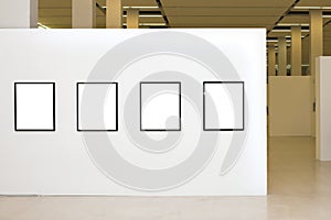 Exhibition with four empty frames on white walls