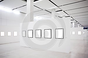 Exhibition with many empty frames on white walls