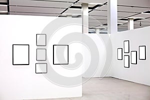 Exhibition with many empty frames on white walls