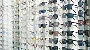 Exhibitor of glasses consisting of shelves of fashionable glasses shown on a wall at the optical shop