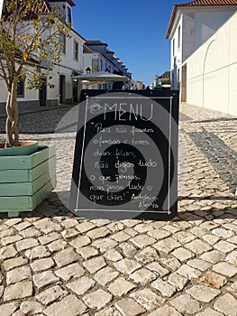 An existential menu put across the southern white paved street in Portugal recites classics photo