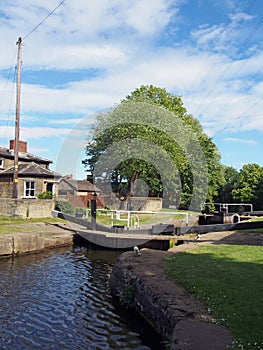 The exit lock gates at brighouse basin on the calder and hebble navigation canal with 19th century lock keepers building