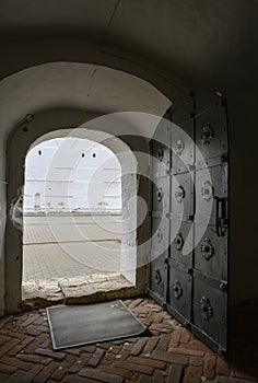 Exit to the courtyard of a medieval monastery with an arched corridor and an ancient wrought iron door