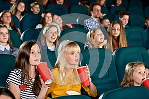 Exited girls watching movie in the cinema.