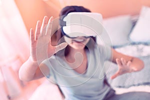 Smiling girl using virtual reality device at home