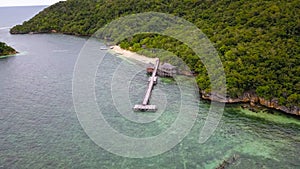 Exotic aerial view of turquoise water with wooden jetty on Flores island Indonesia