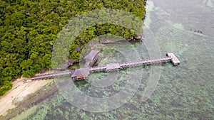 Exotic aerial view of turquoise water with wooden jetty on Flores island Indonesia