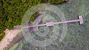 Exotic aerial view of turquoise water with wooden jetty on Flores island Indonesia